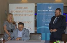 Wiceprezes Sudeckiego Stowarzyszenia BHP Piotr Jakubowski podpisuje porozumienie.